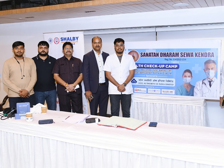 Health camp medical team posing together beside the event banner